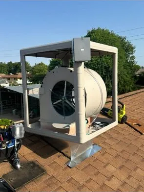 Evaporative cooler cabinet being installed on a rooftop curb